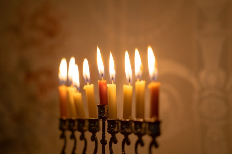 A beautifully lit menorah with burning candles symbolizing the Hanukkah celebration in a warm indoor setting.