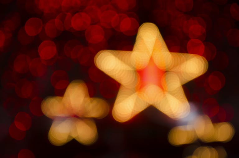 Blurred gold and red star-shaped lights creating a festive holiday atmosphere.
